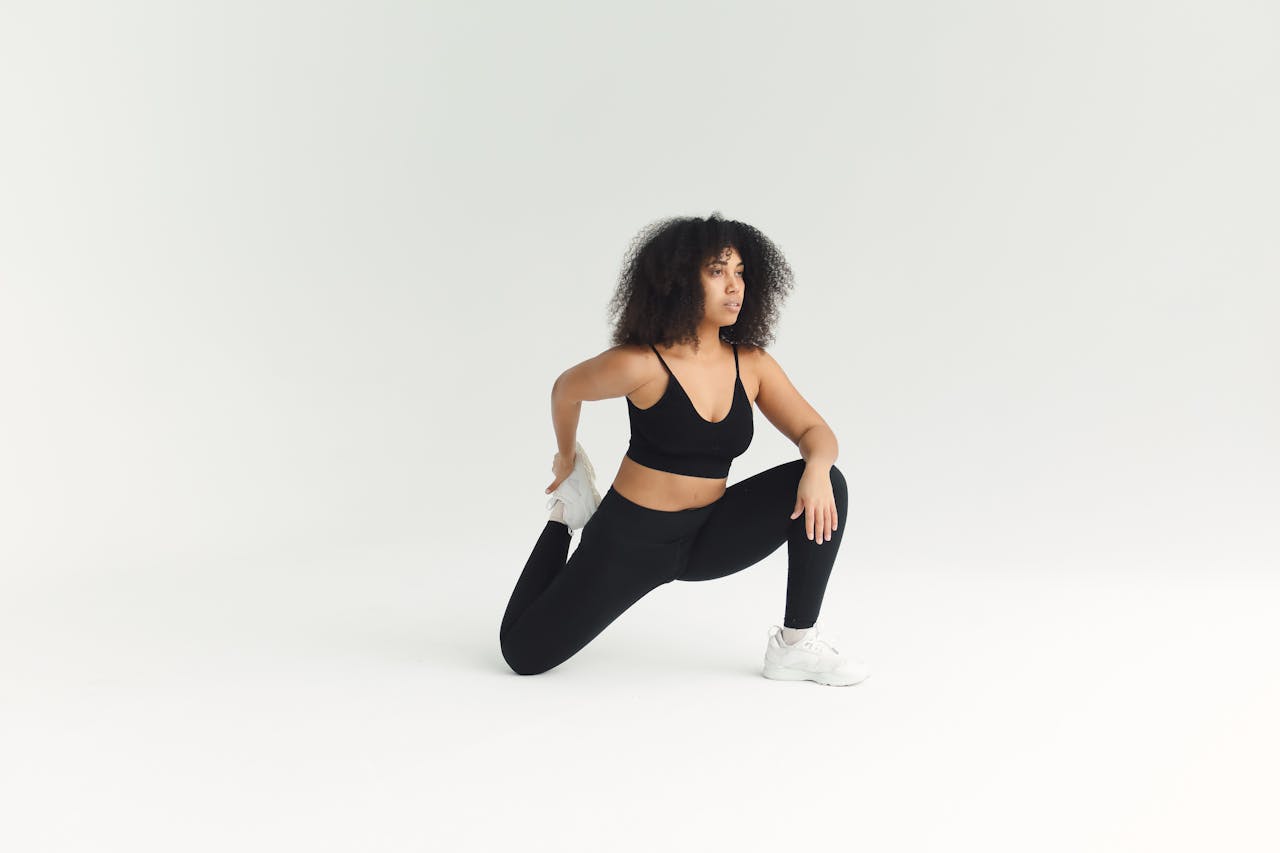 Adult woman engaged in fitness stretching routine in a bright minimalist studio.